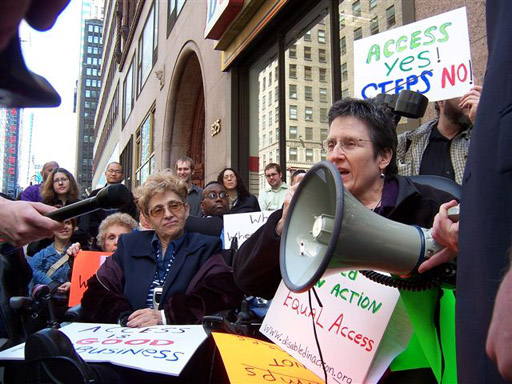 larger photo of Jean Ryan, one of the plaintiffs in the settlement, speaking