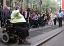 photo of people in wheelchairs and pedestrians at Penn Station taxi stand