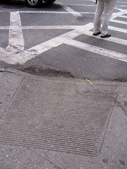 Photo of hole at the foot of a curb cut