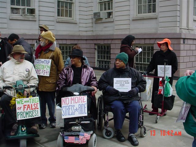 A group of people at the press conference holding some signs