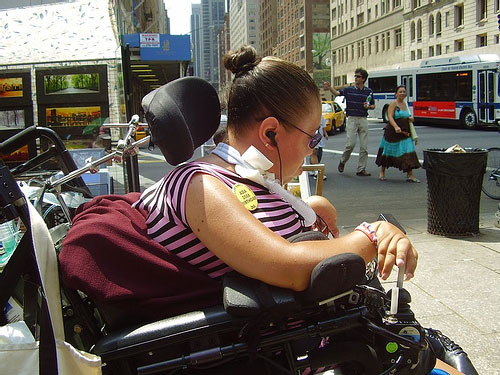 A woman in a wheelchair on the sidewalk