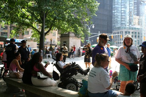 People are seen gathered in New York City's Central Park at Columbus Circle