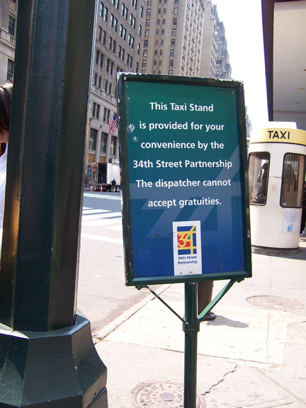 sign on sidewalk in front of Penn Station taxi stand