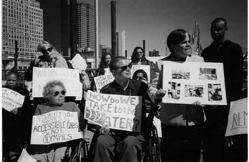 Margarita Lopez, a politician, is standing with a group of people with disabilities while she passionately talks about the inaccessibility of the ferries